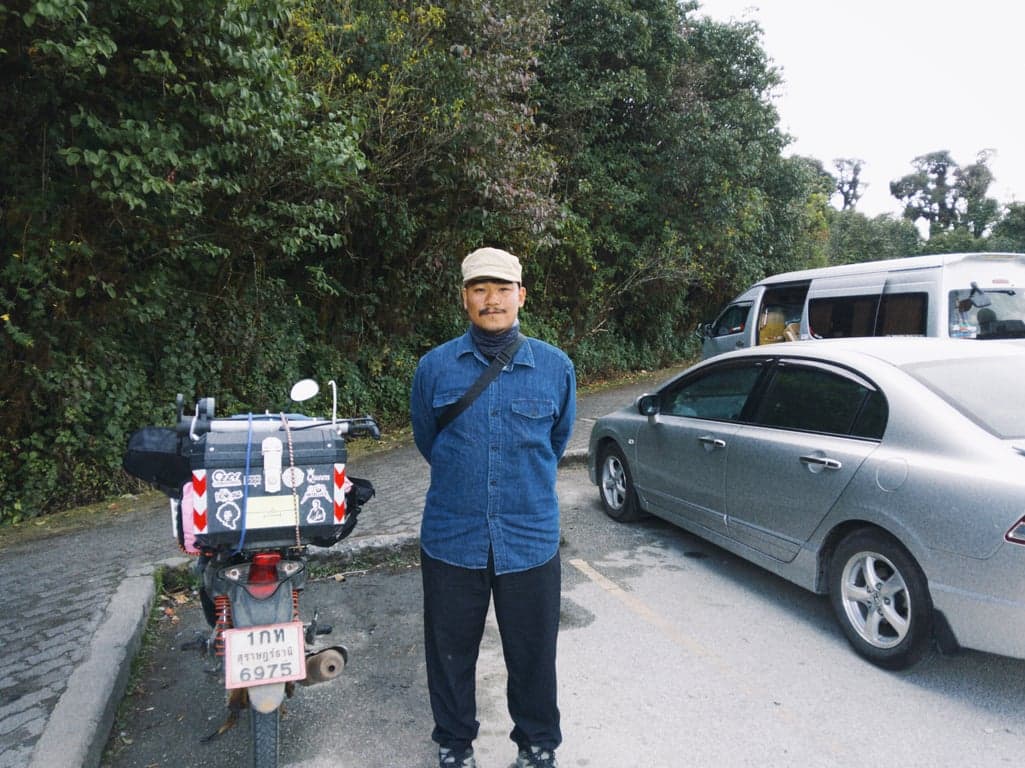 Standing at the summit of Doi Inthanon, the highest peak in Thailand, in Chiang Mai with an altitude of 2565 meters.