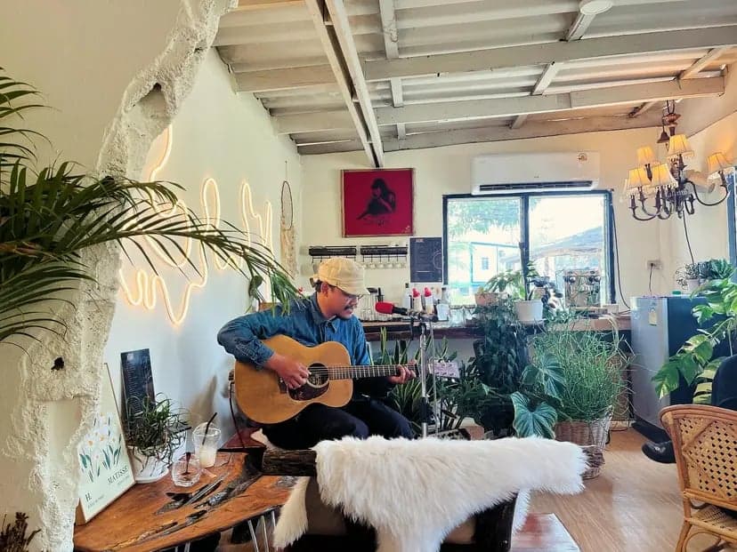 I reunited with my musician friends after several years. I used to be a singer and songwriter, and in this picture, I'm playing my new song 'Mae Sao Patpong' at their brand-new cafe.